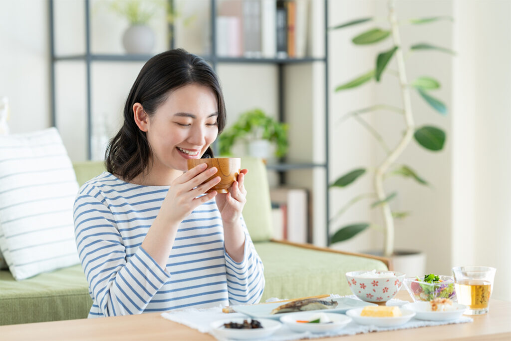 お味噌汁を飲む女性